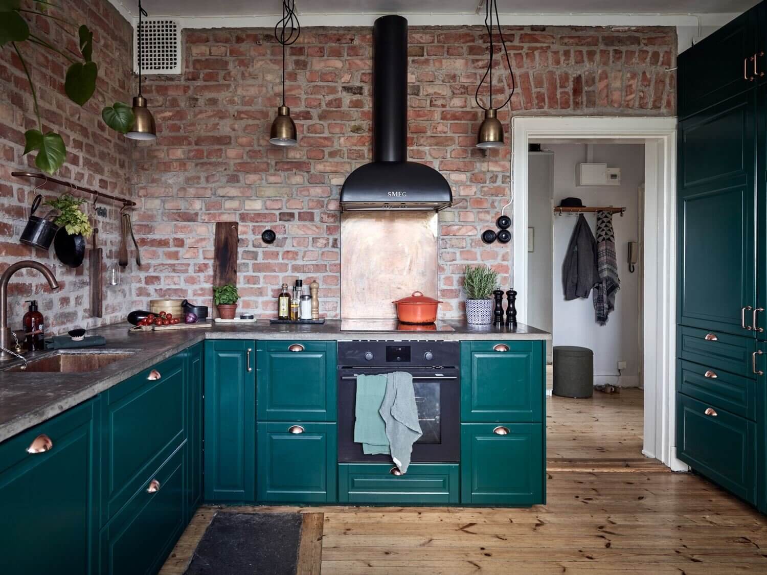 A Green Kitchen with Exposed Brick in a Scandi Apartment