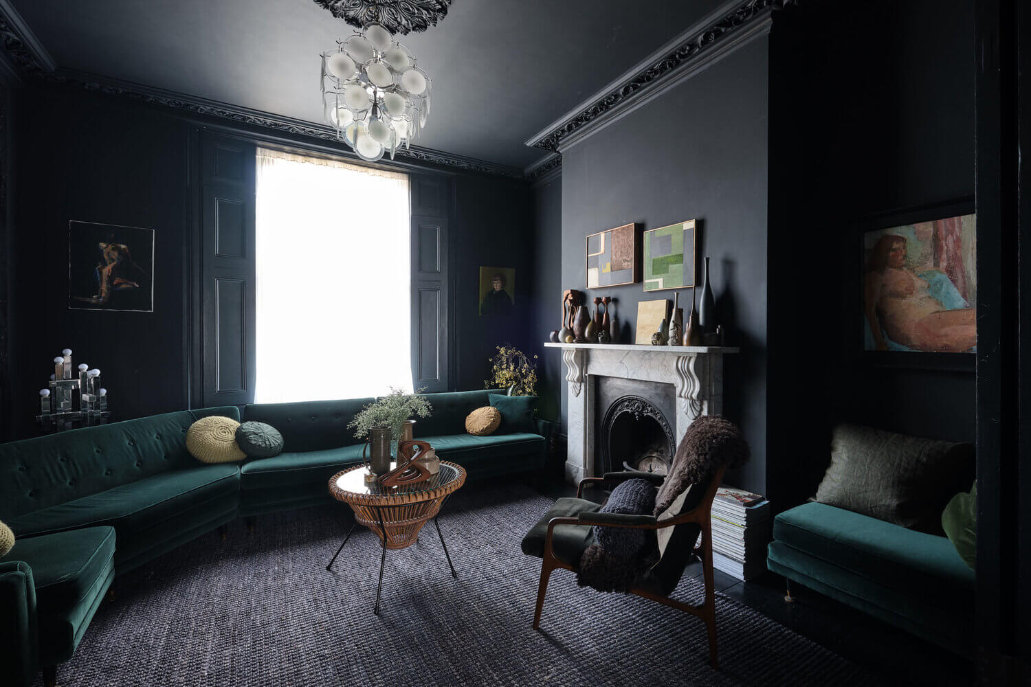 Amoodysittingroomwithdarkgreenvelvetsofaandfireplace TheNordroom Moody Colors and Mid-Century Design in a Unique Victorian Home