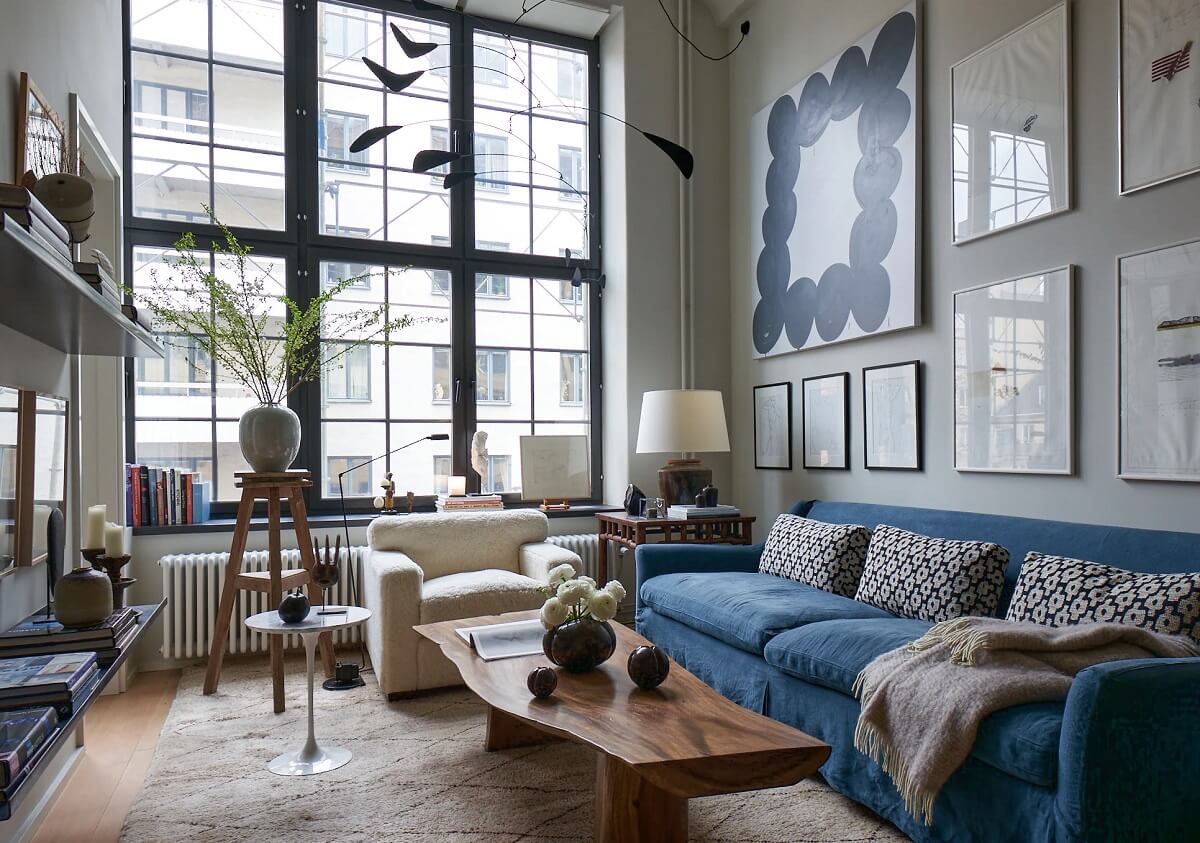art-filled-living-room-high-ceilings-blue-sofa-nordroom