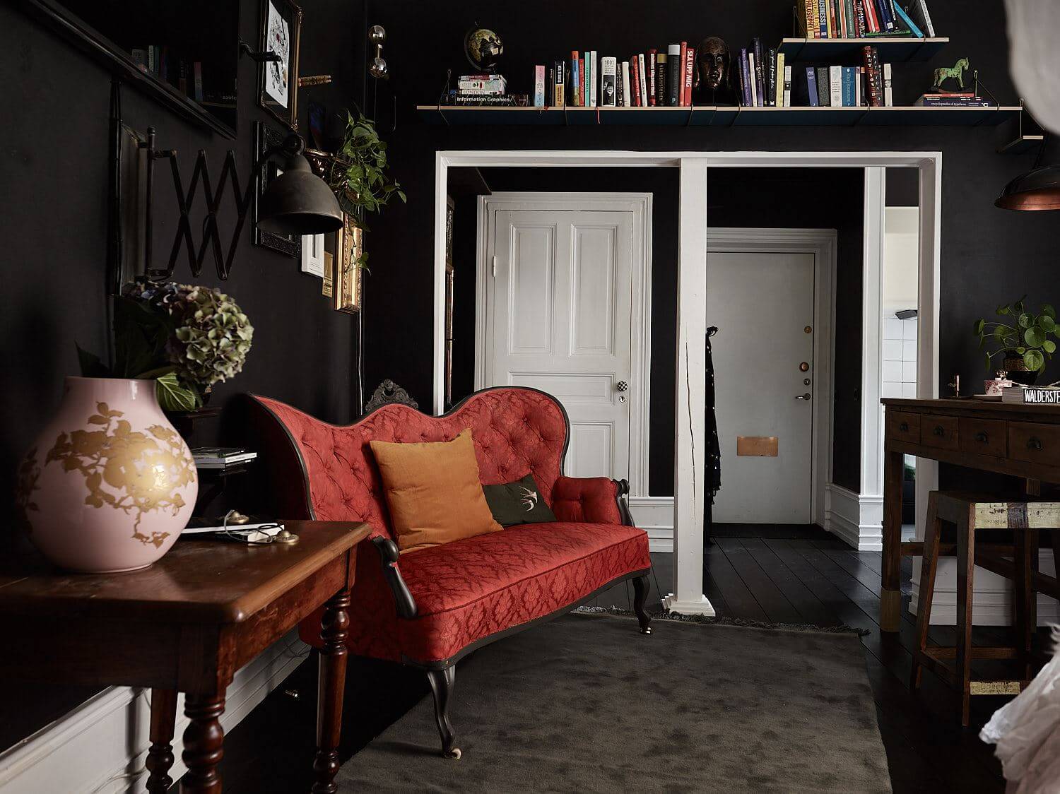 black-studio-apartment-red-vintage-sofa-bookshelves-nordroom