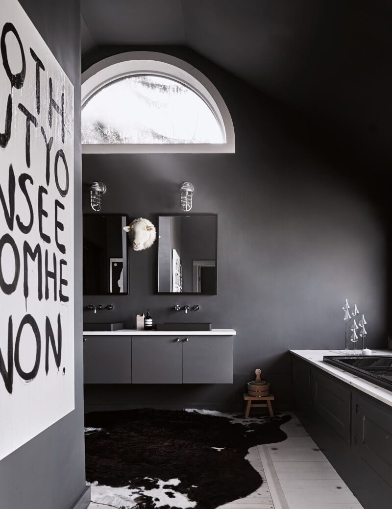 Black and white cow hide carpet matched with gray walls and black bath.