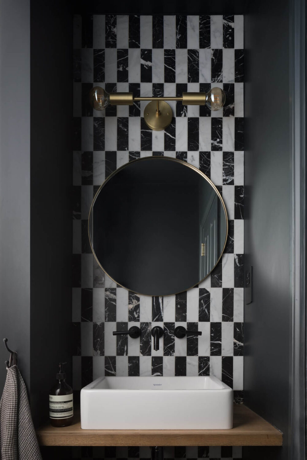 powder-room-round-mirror-black-white-tiles-nordroom
