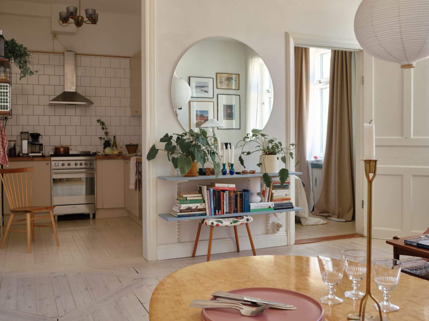 open-plan-living-room-kitchen-round-mirror-blue-shelves-nordroom