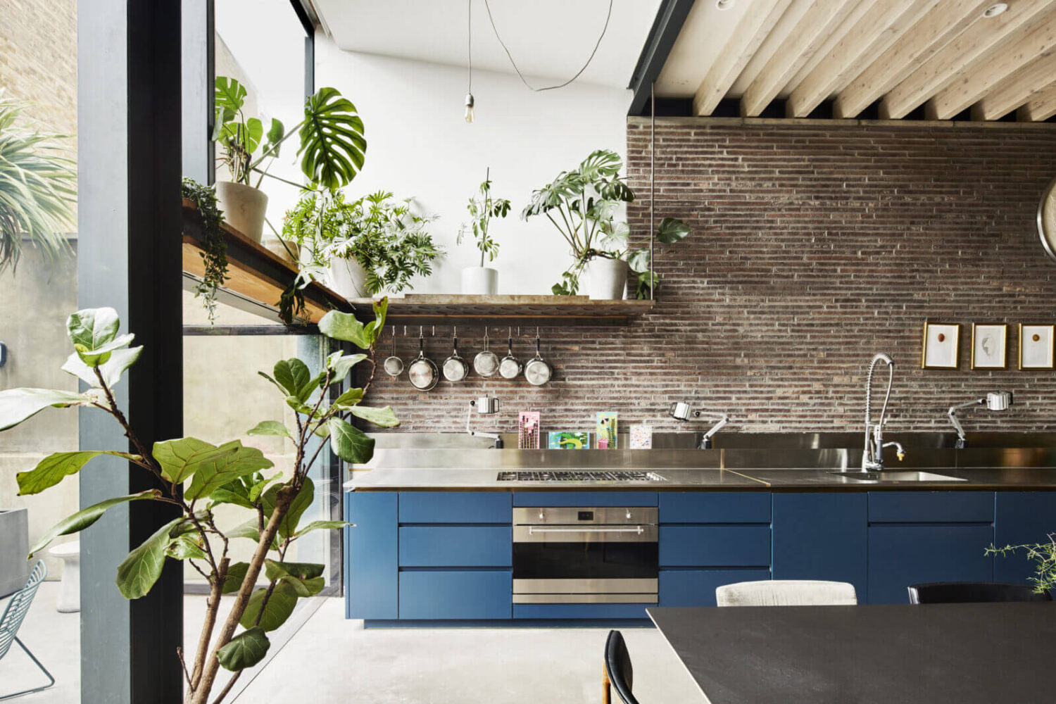 blue-kitchen-cabinets-brick-wall-wooden-beams-glass-wall-nordroom