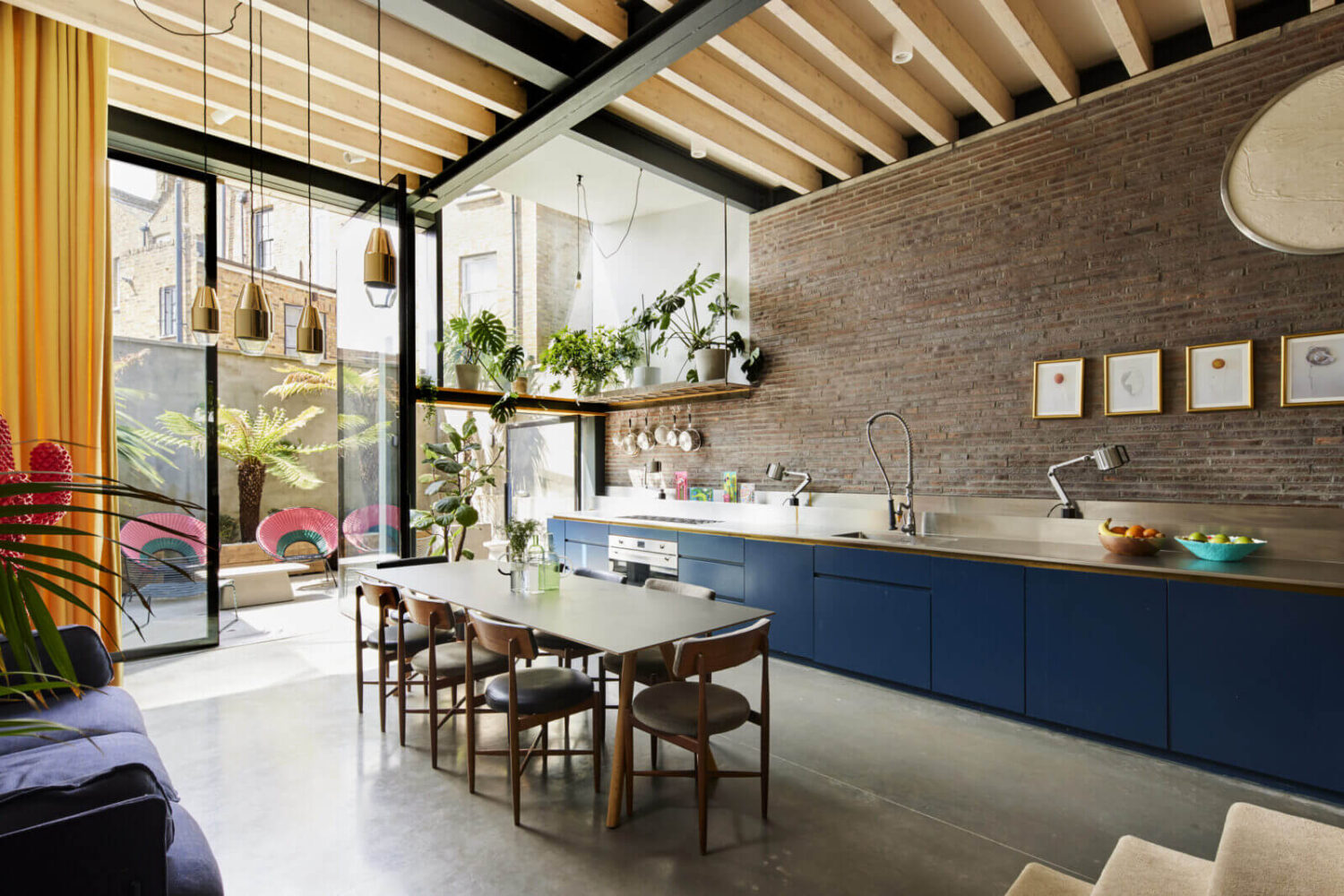 kitchen-blue-cabinets-brick-wall-dining-table-high-ceilings-nordroom