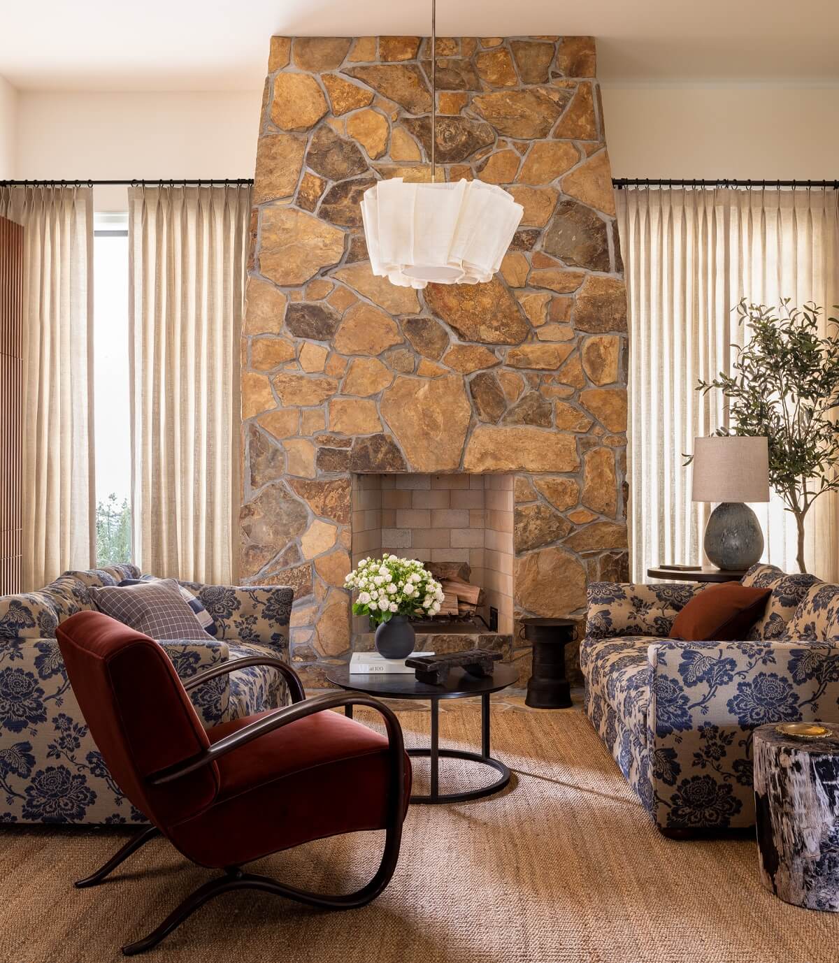 sitting-room-stone-fireplace-blue-patterned-sofas-red-armchair-nordroom