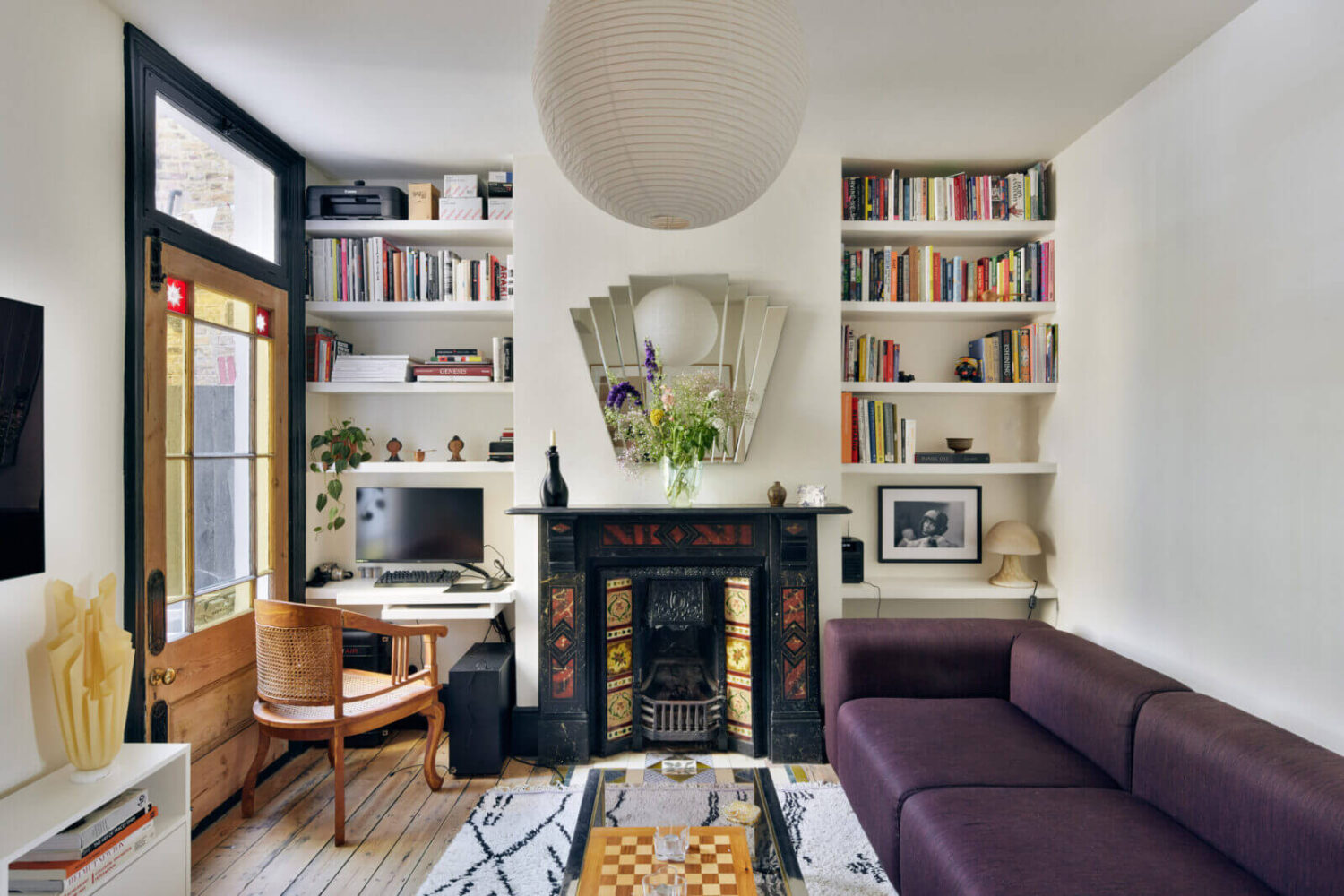 A One-Bedroom Apartment with Colorful Rooms 1 sitting-room-fireplace-bookshelfs-purple-sofa-small-home-office-nordroom