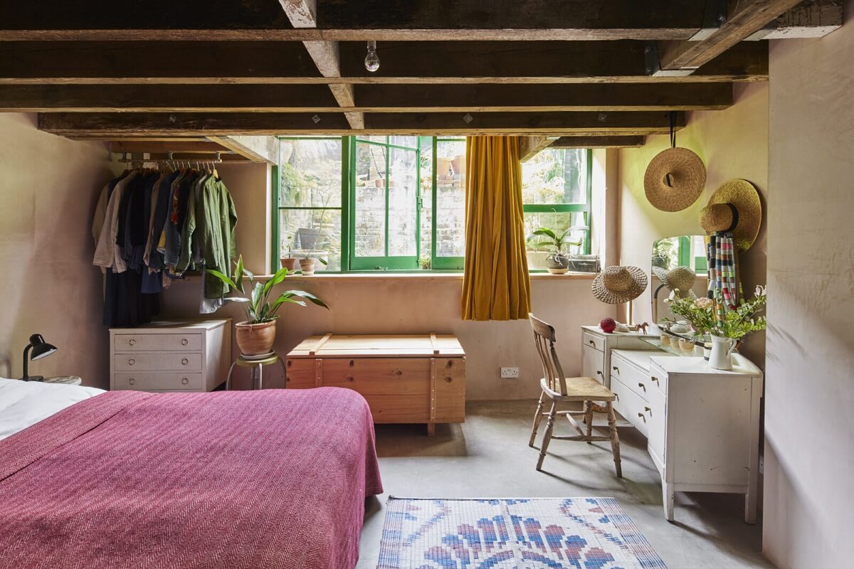 bedroom-pink-bedspread-exposed-wooden-ceiling-vanity-table-nordroom