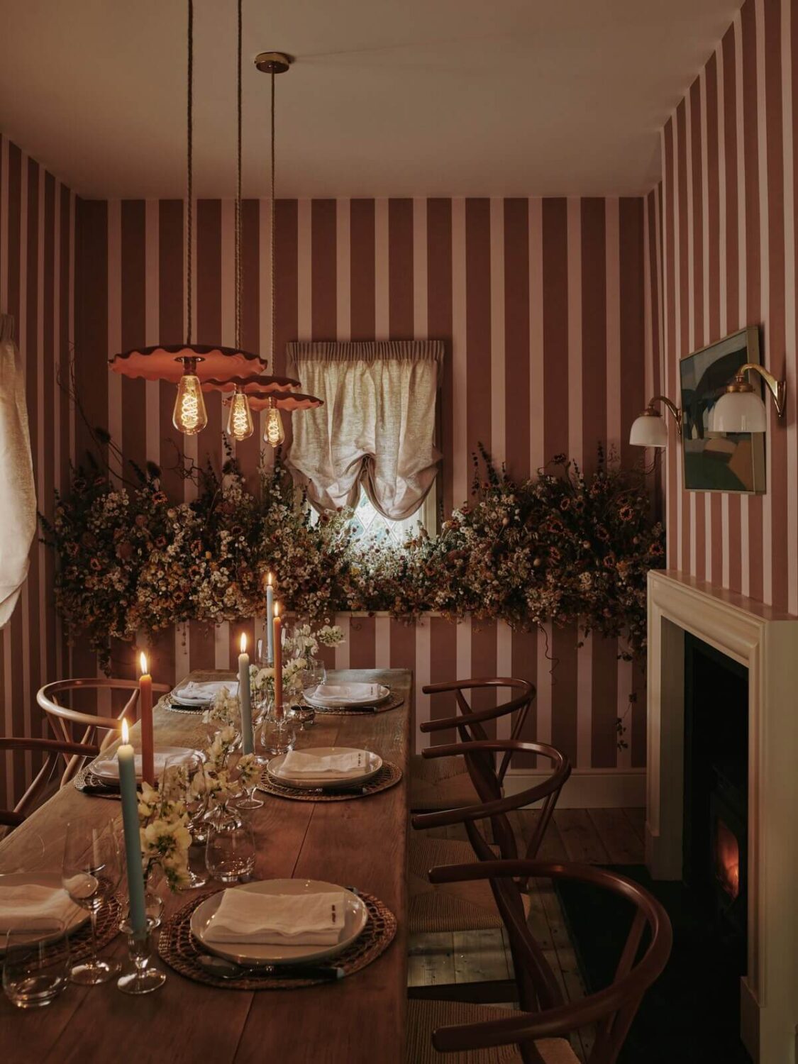 A Magical Pink Cottage in the English Countryside 1 cozy-dining-room-striped-wallpaper-fireplace-rustic-table-wishbone-chairs-nordroom
