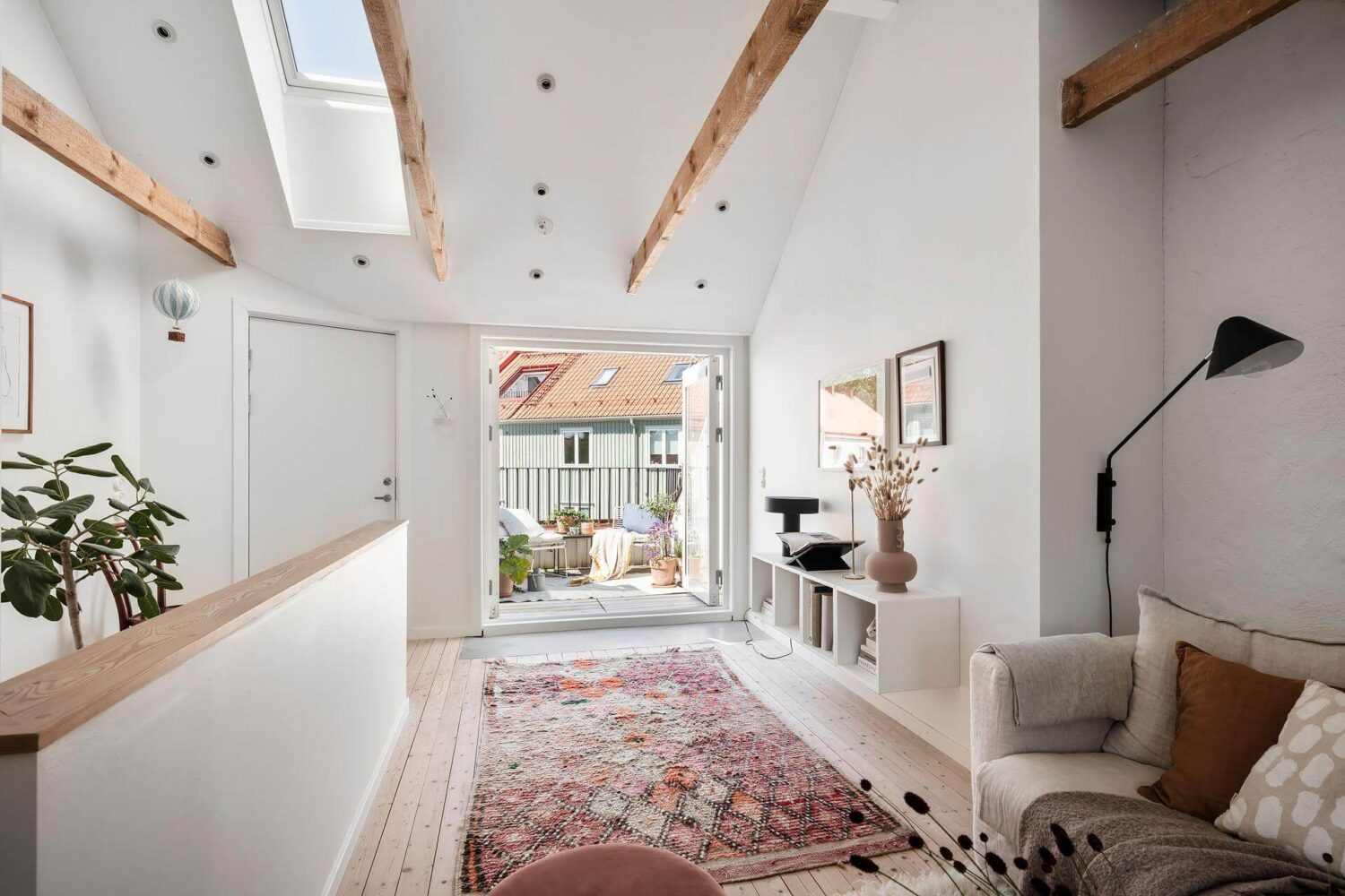 living-room-attic-apartment-exposed-beams-pink-rug-nordroom