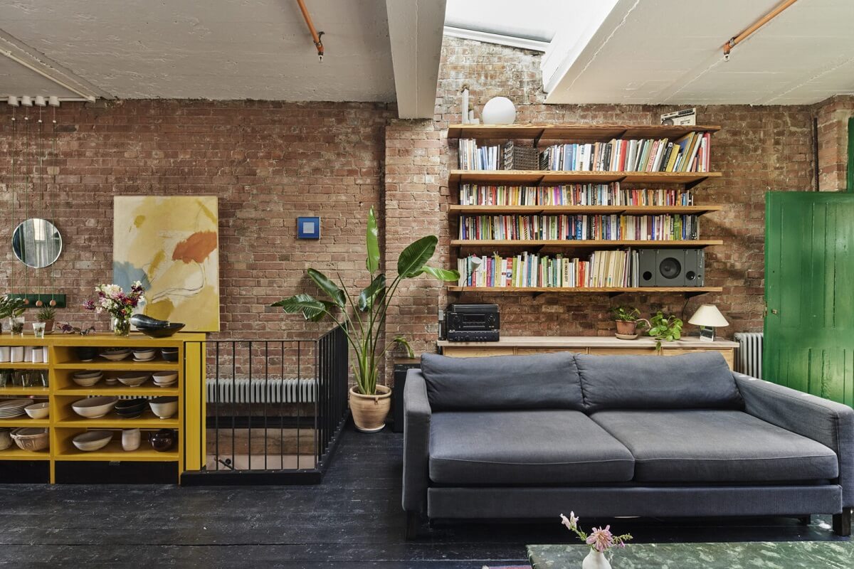 living-room-brick-walls-black-wooden-floor-floating-bookshelfs-nordroom