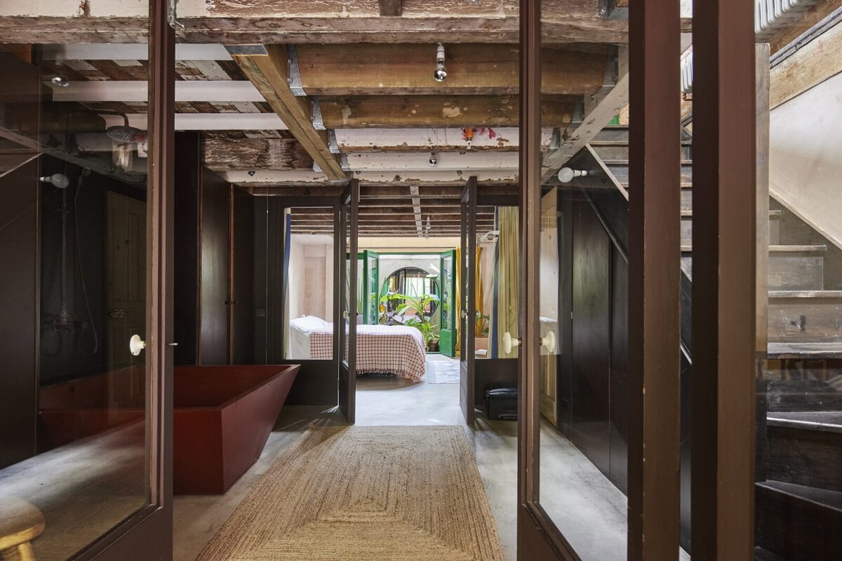 open-plan-bedroom-bathroom-floor-exposed-wooden-ceiling-nordroom
