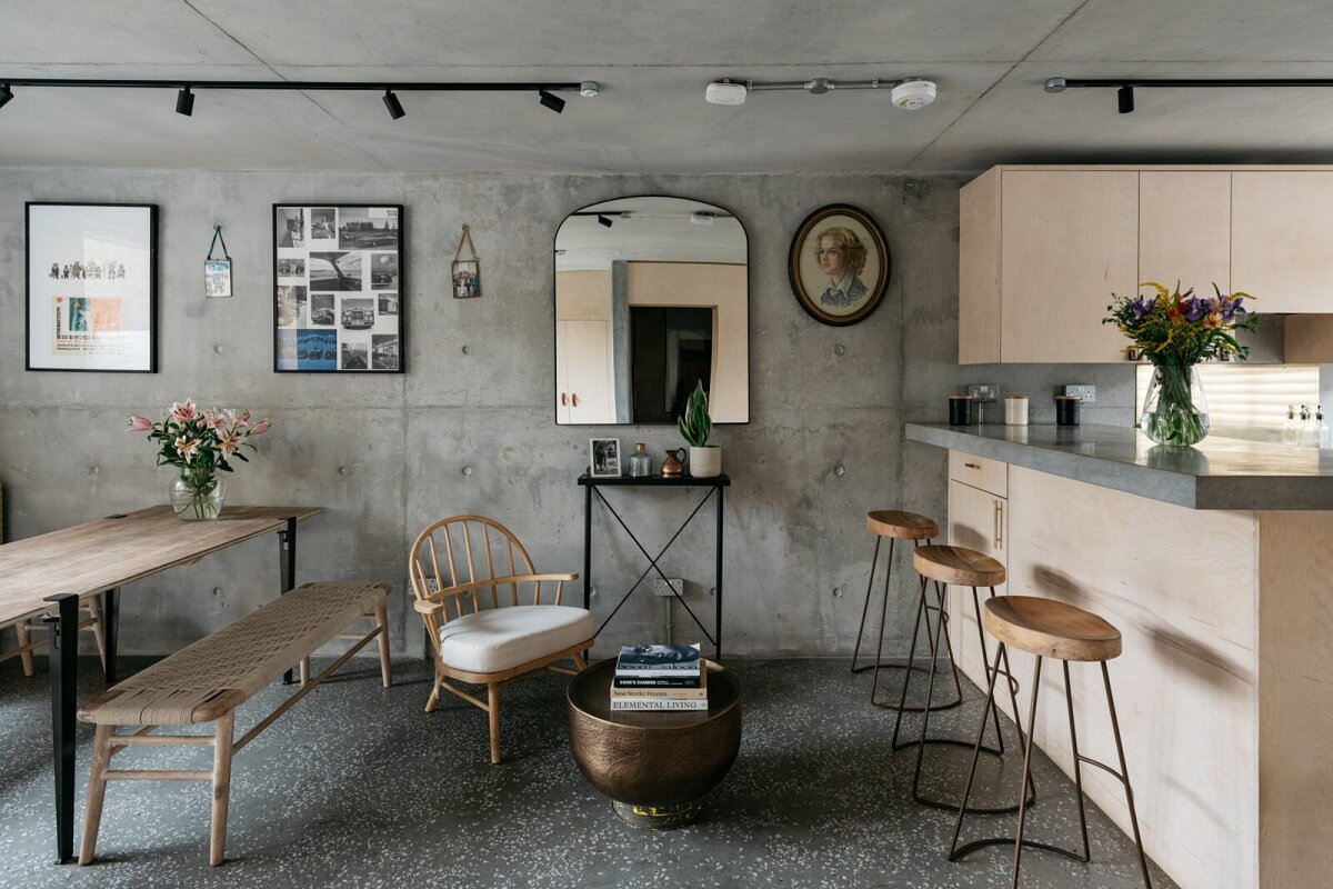 open-plan-living-space-concrete-walls-breakfast-bar-terrazzo-floor-nordroom