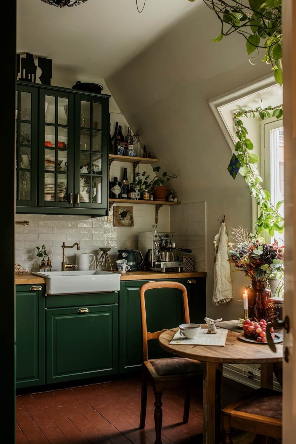 cozy-green-kitchen-cabinets-slanted-ceiling-small-dining-table-terracotta-floor-tiles-nordroom