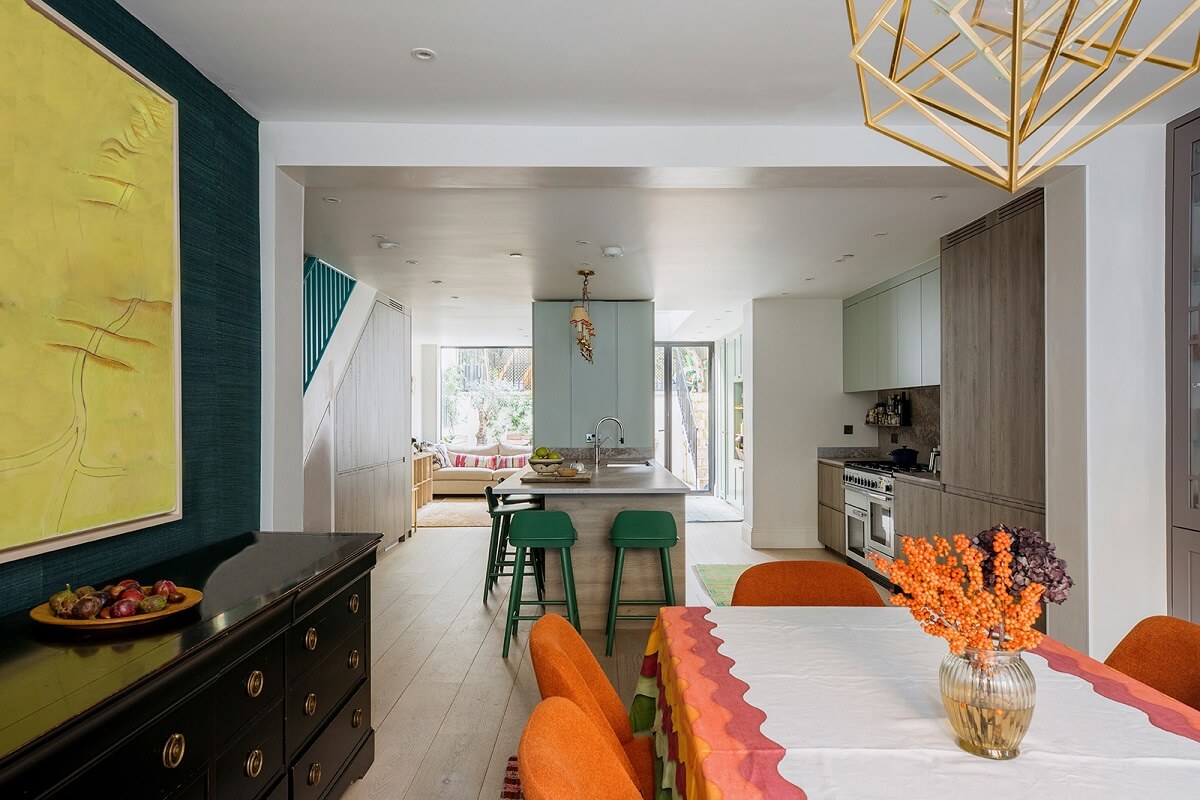 open-plan-kitchen-dining-room-teal-wallpaper-orange-chairs-nordroom