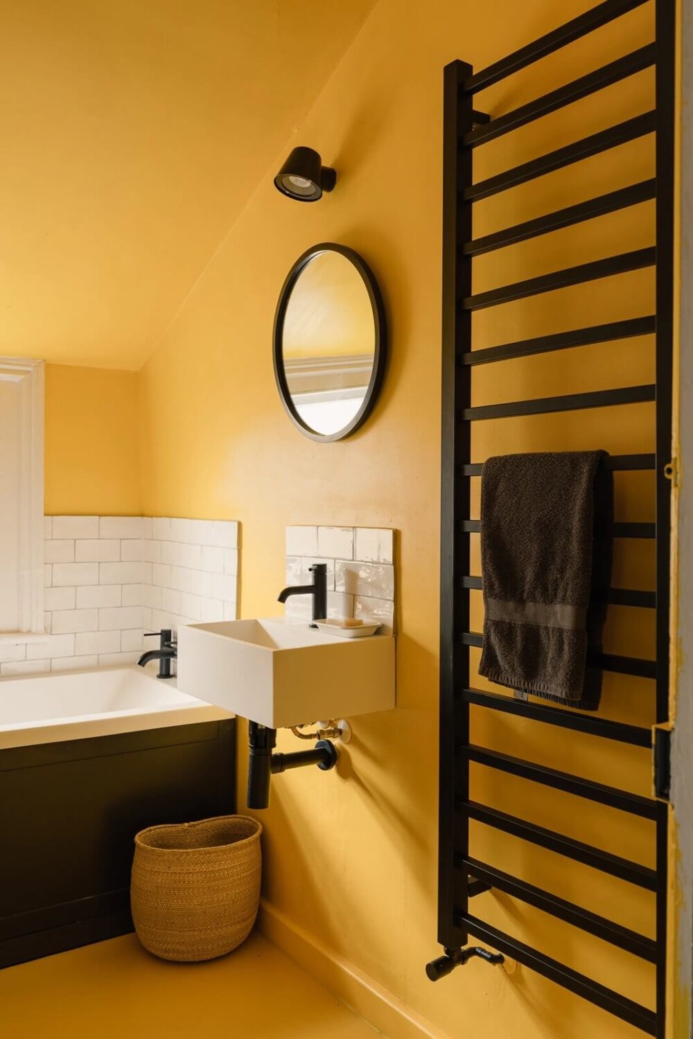 bathroom-yellow-walls-ceiling-floor-black-fittings-nordroom