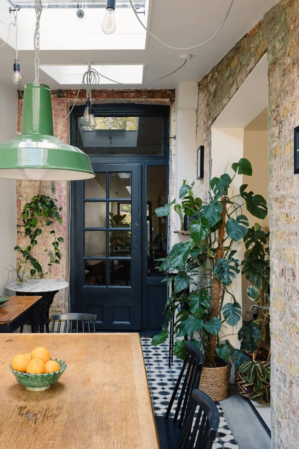 dining-room-exposed-brick-wall-black-doors-skylight-nordroom