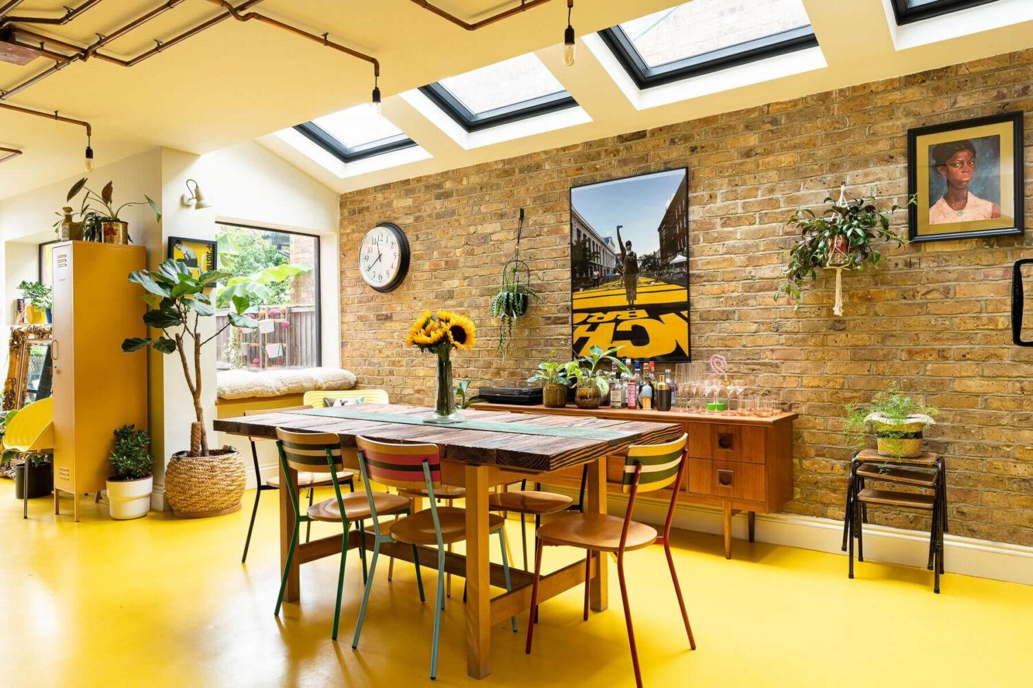 kitchen-dining-room-brick-wall-skylights-yellow-floor-nordroom