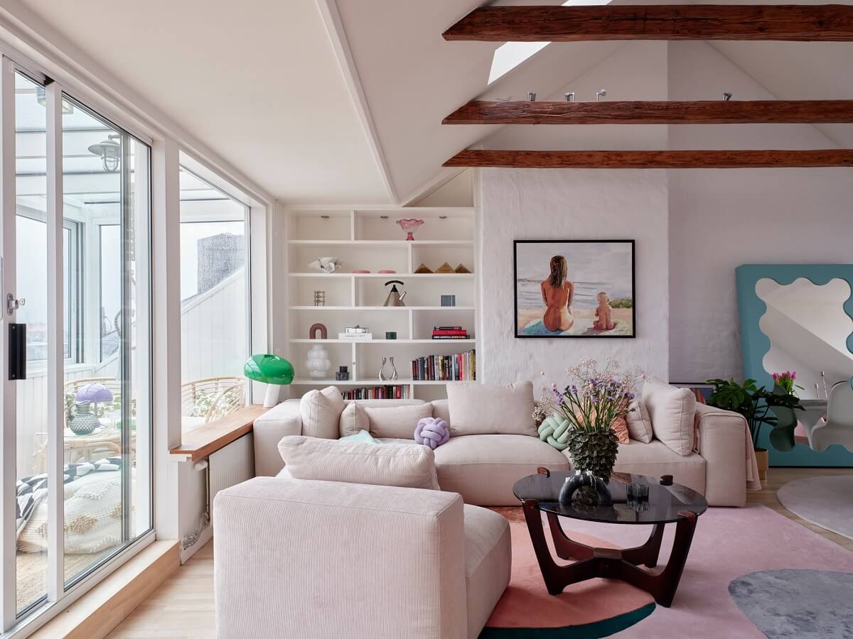 sitting-room-bookshelfs-pastel-color-accents-wooden-ceiling-beams-nordroom