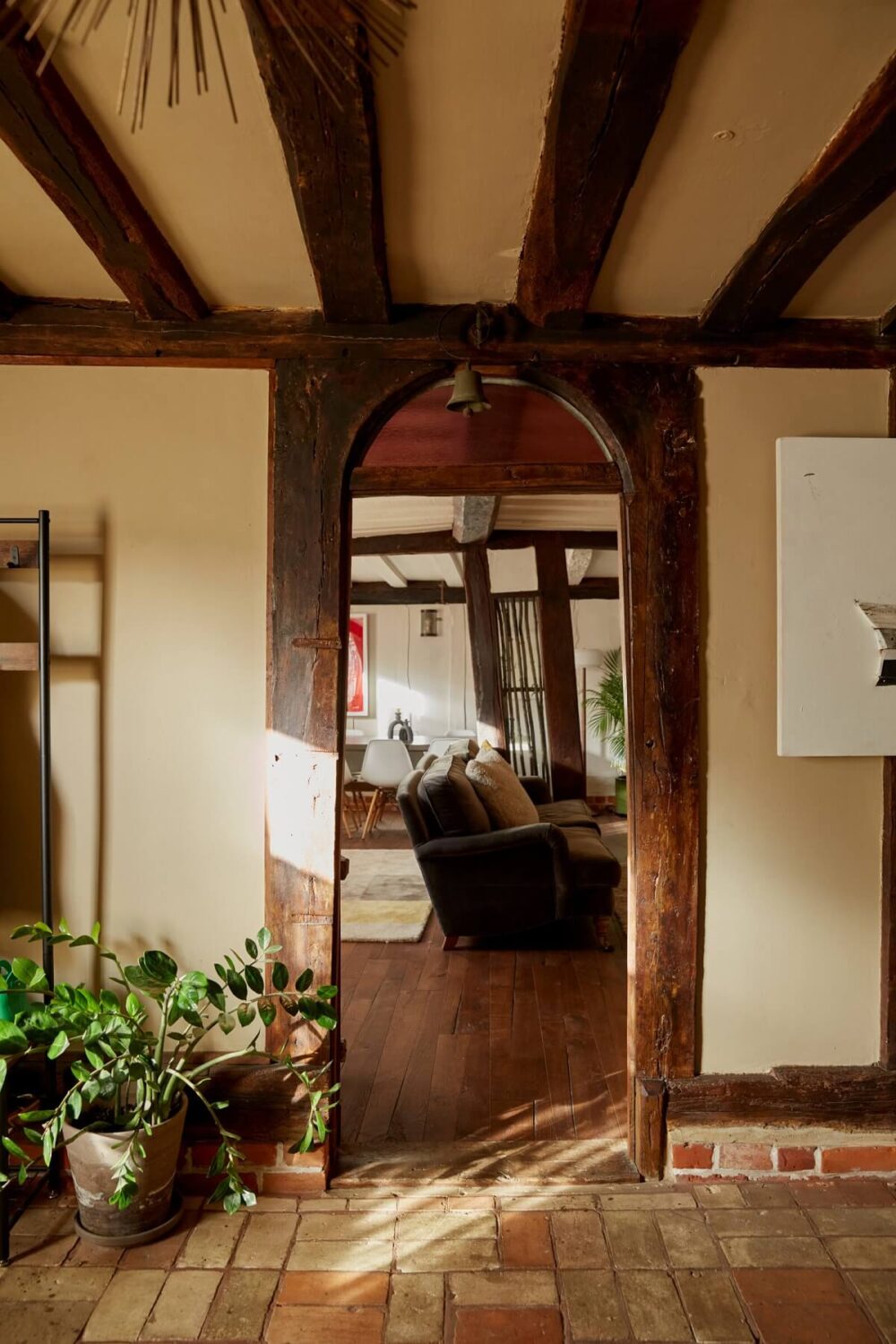 arched-wooden-doorway-living-room-hallway-stone-floor-exposed-beams-nordroom
