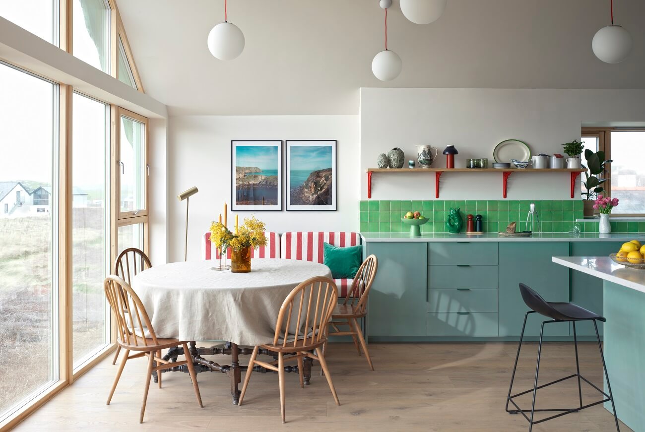 kitchen-blue-cabinets-dining-space-bench-striped-red-fabrics-green-backsplash-tiles-nordroom