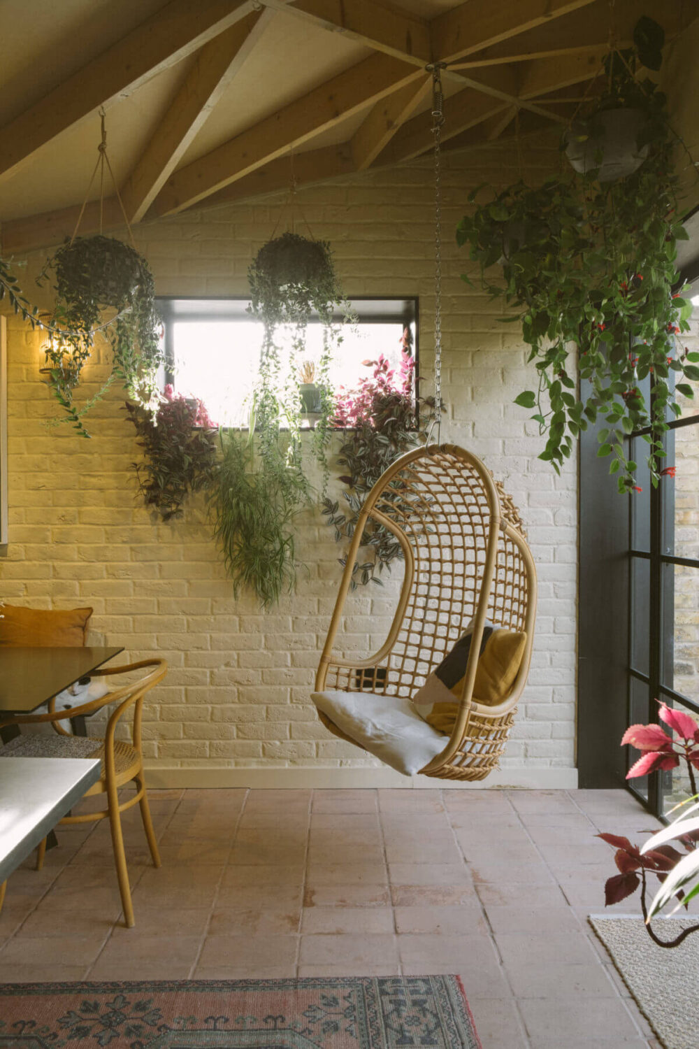 kitchen-stone-floor-wooden-beams-hanging-rattan-chair-plants-nordroom