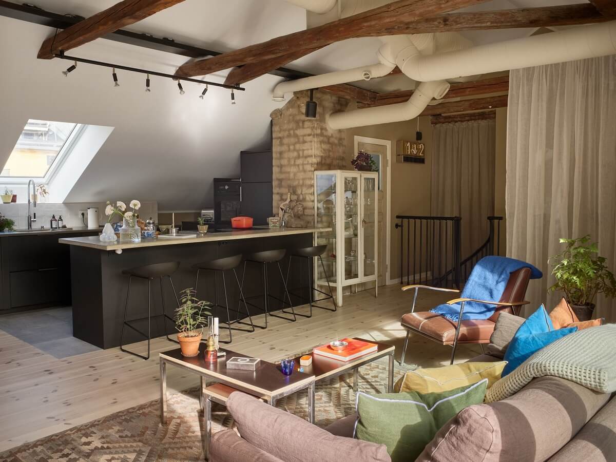 open-plan-living-space-penthouse-loft-black-kitchen-exposed-brick-wooden-beams-nordroom