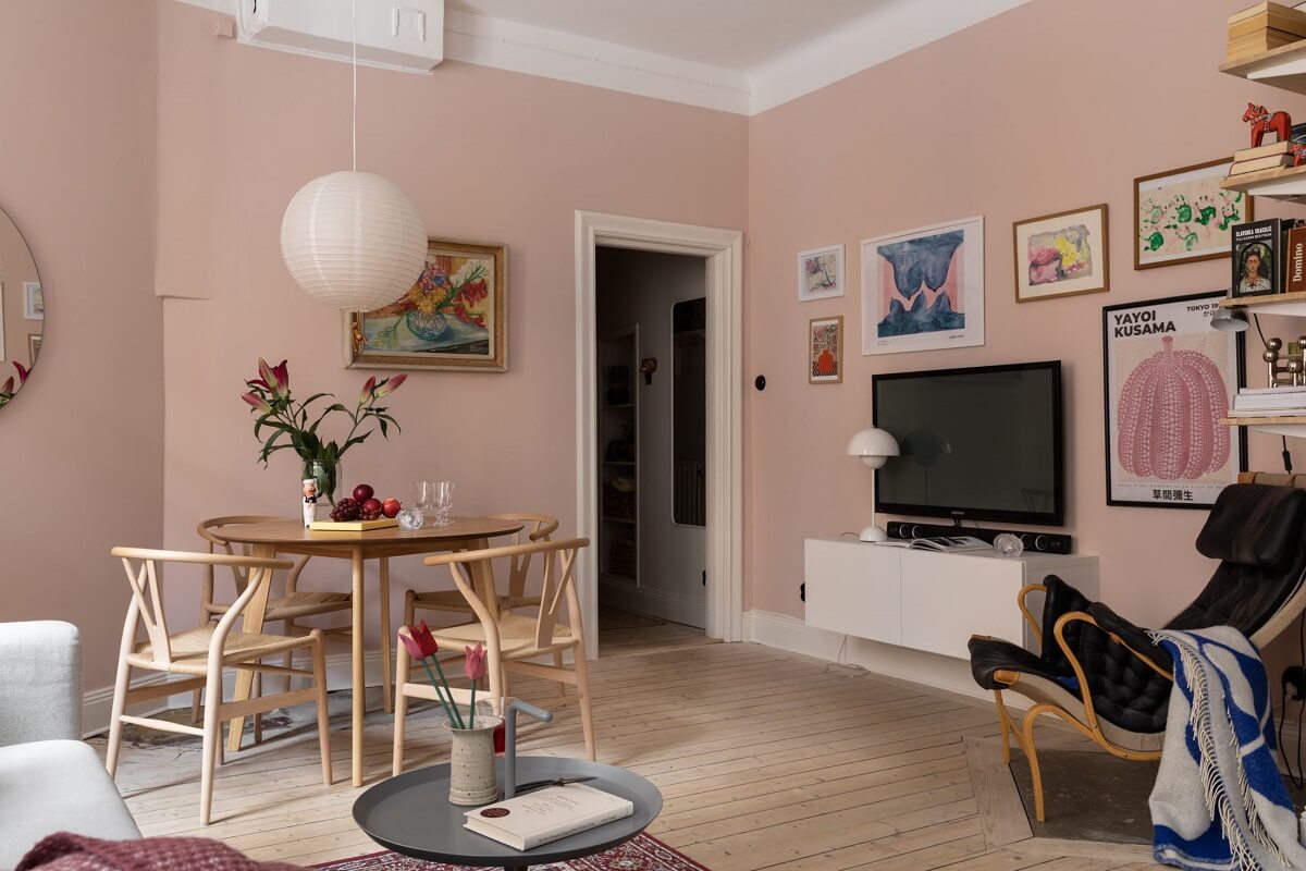 pink-walls-living-room-round-dining-table-wooden-floor-art-nordroom