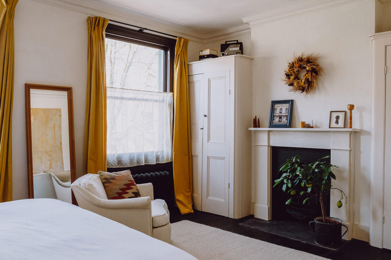 white-bedroom-ochre-yellow-curtains-fireplace-nordroom