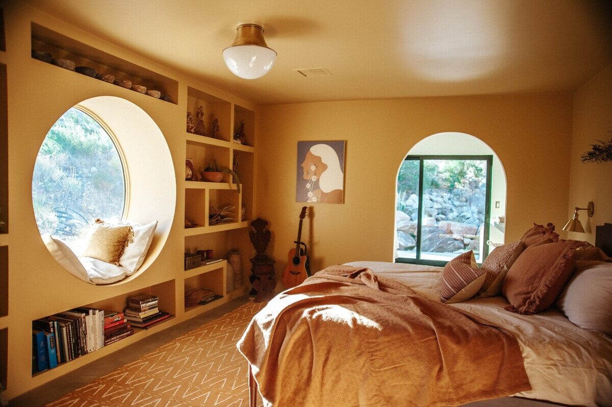 yellow-bedroom-painted-ceiling-built-in-bookcases-round-mirror-nordroom