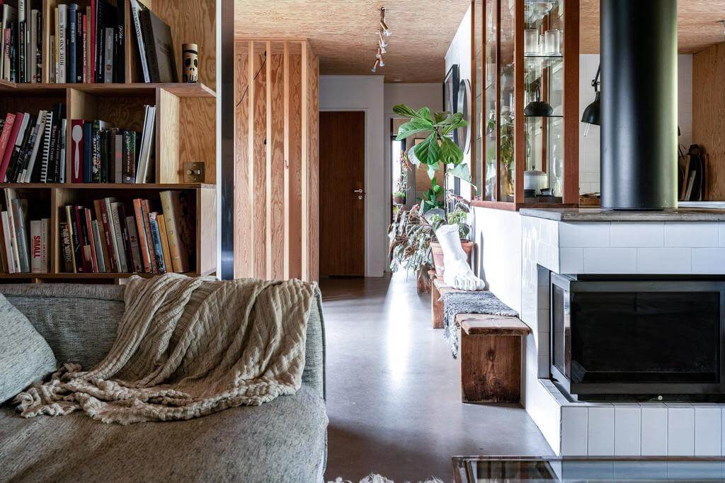 open-plan-living-space-concrete-floor-fireplace-bookshelves-nordroom