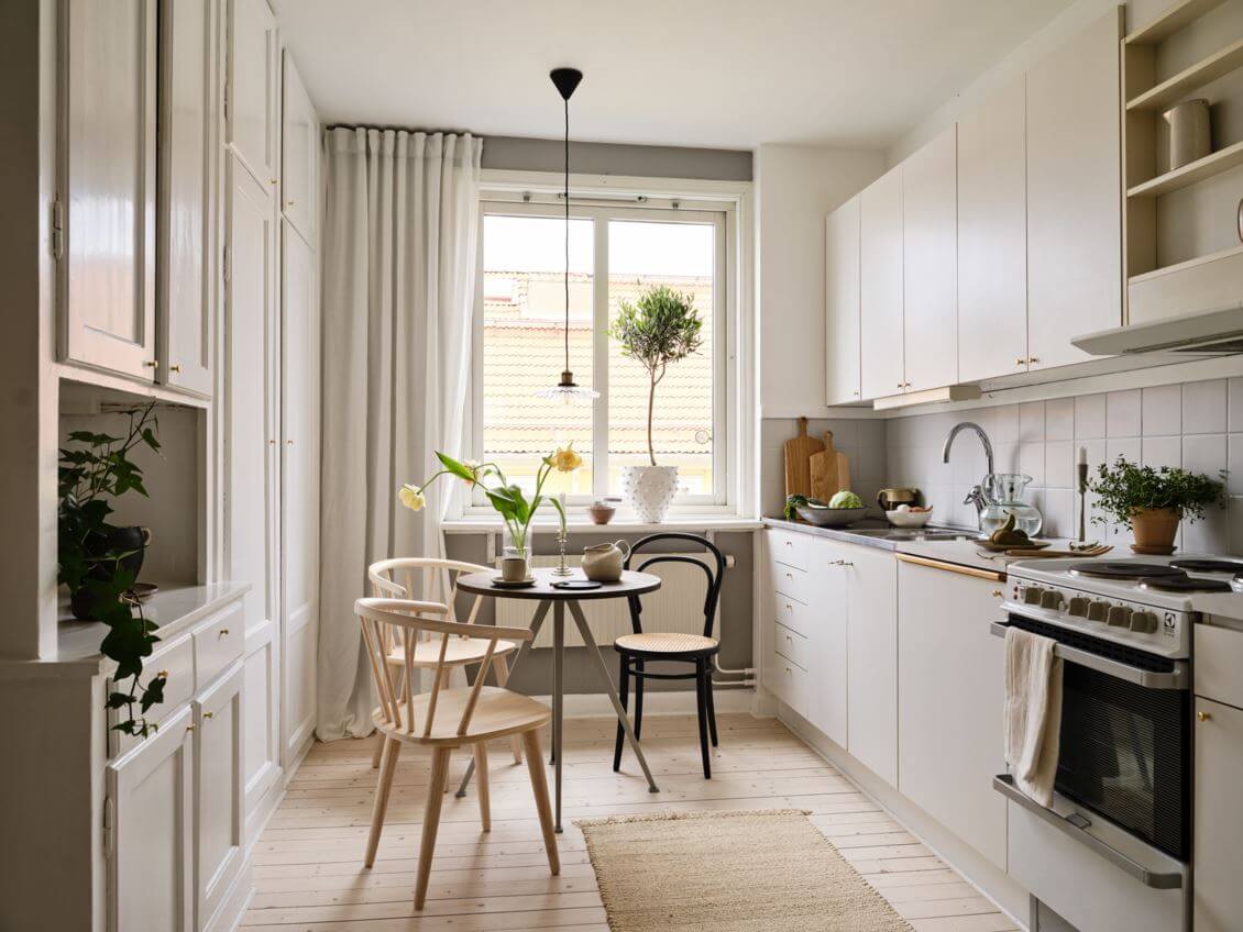 kitchen-studio-apartment-gray-walls-white-cabinets-small-round-dining-table-nordroom