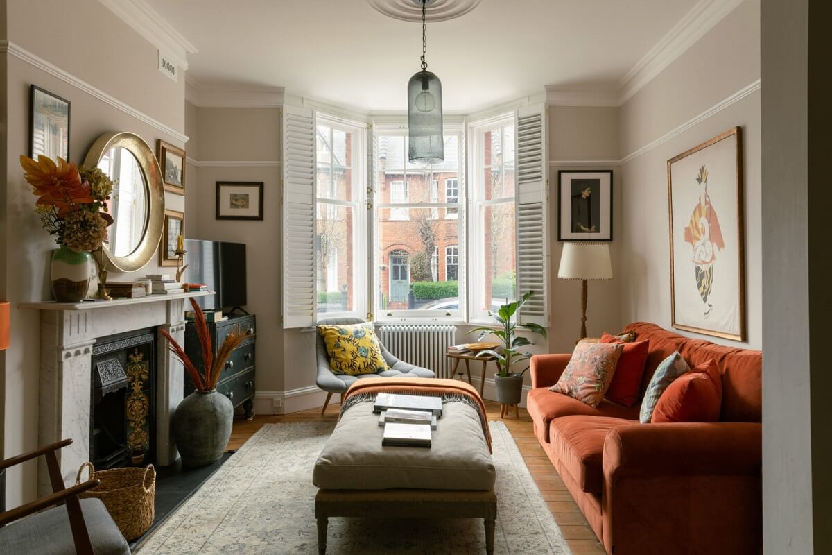 living-room-light-gray-walls-red-sofa-bay-window-nordroom