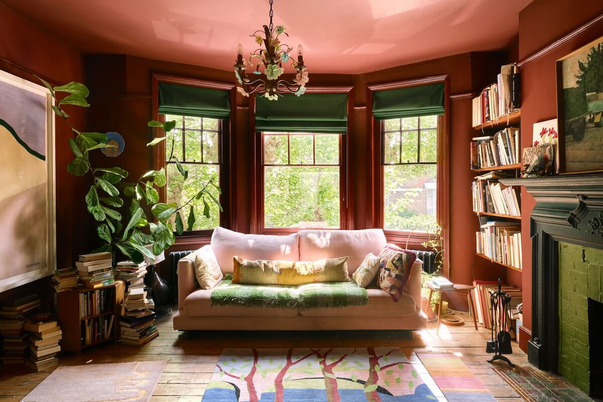 bay-window-living-room-reddish-brown-walls-bookshelves-nordroom