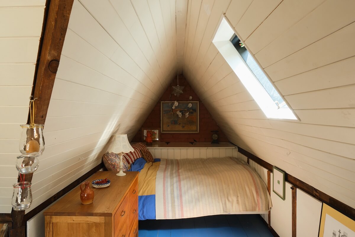 attic-bedroom-slanted-ceiling-blue-painted-floorboards-nordroom