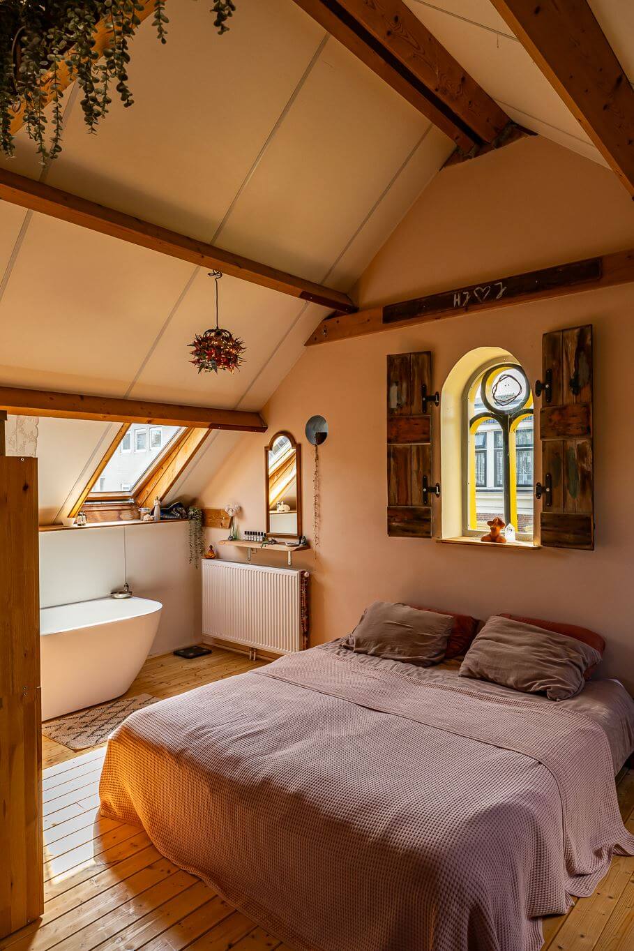 attic-bedroom-wooden-shutters-exposed-wooden-beams-freestanding-bath-nordroom