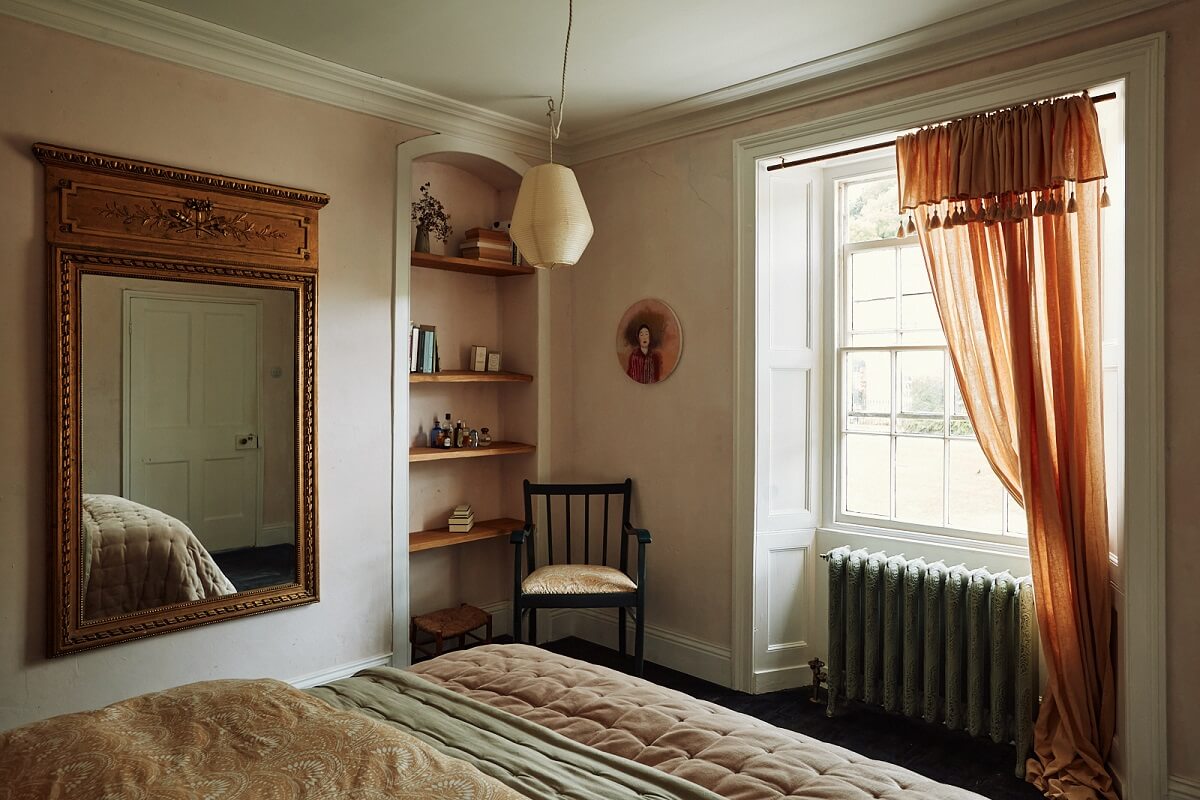 bedroom-plaster-walls-terracotta-curtain-large-mirror-built-in-shelves-nordroom