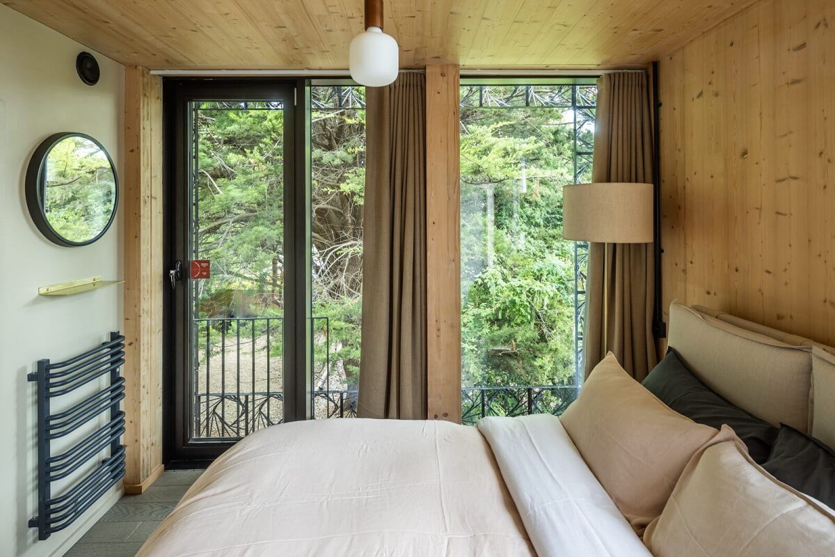 bedroom-wooden-walls-balcony-round-mirror-nordroom