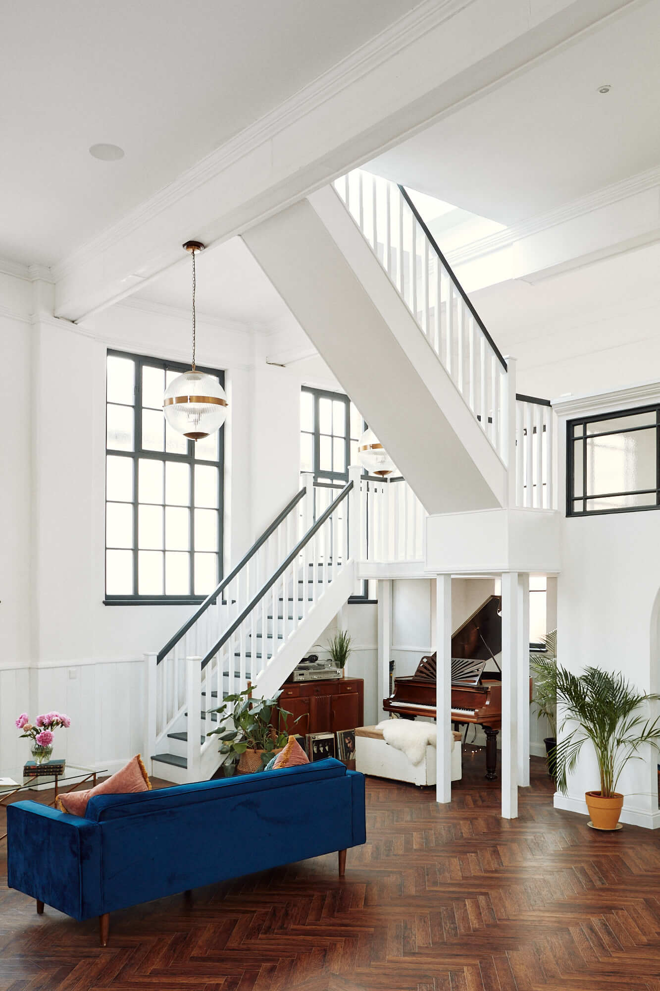 double-height-loft-style-living-room-herringbone-floor-blue-couch-nordroom