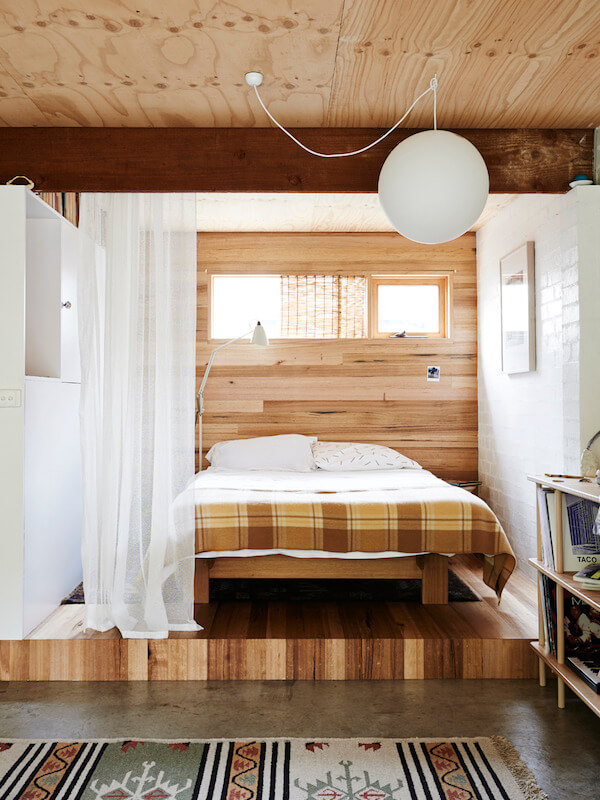 raised-wooden-bedroom-area-studio-with-curtain-room-divider-nordroom