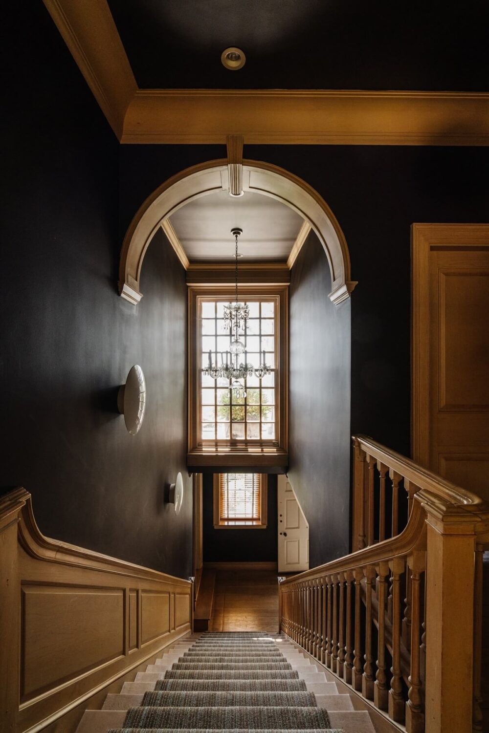 wooden-staircase-black-walls-arch-stained-glass-window-nordroom