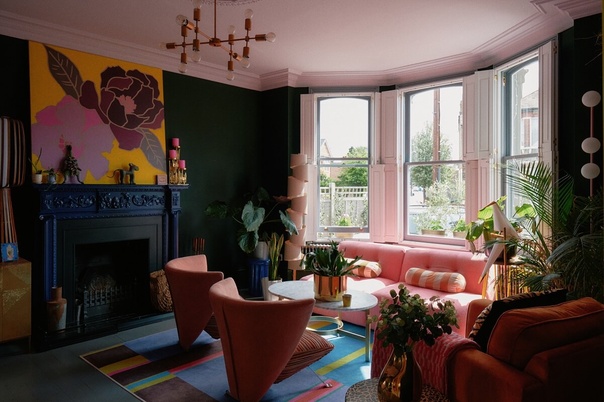 colorful-living-room-green-walls-pink-sofa-blue-fireplace-nordroom