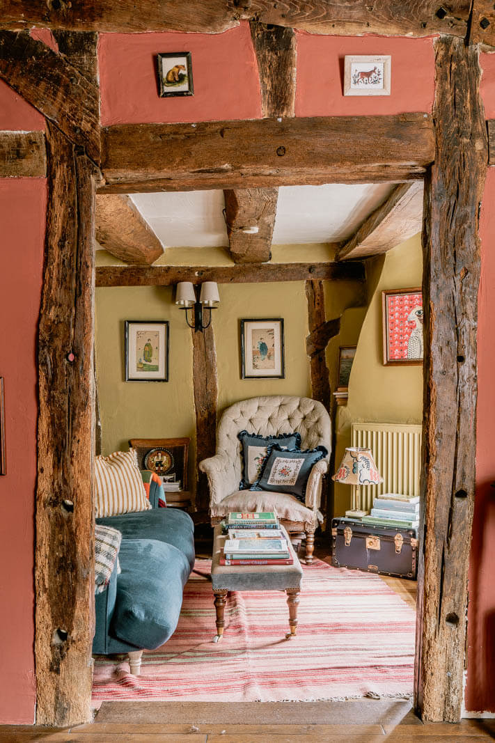 exposed-beams-pink-walls-cottage-living-room-nordroom