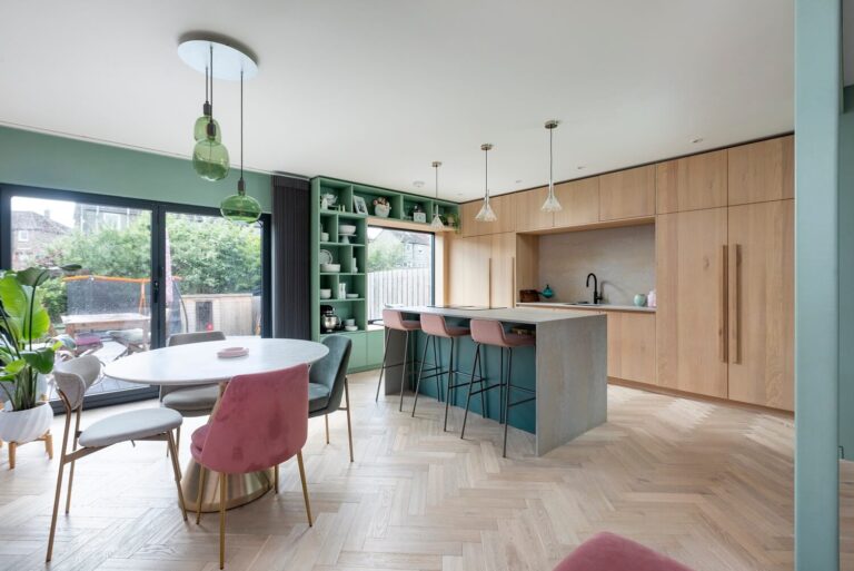 open-plan-kitchen-dining-green-pink-color-palette-oak-cabinets-nordroom