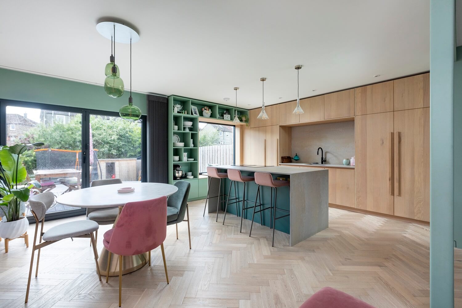 An Open-Plan Living and Kitchen in Green and Pink Tones