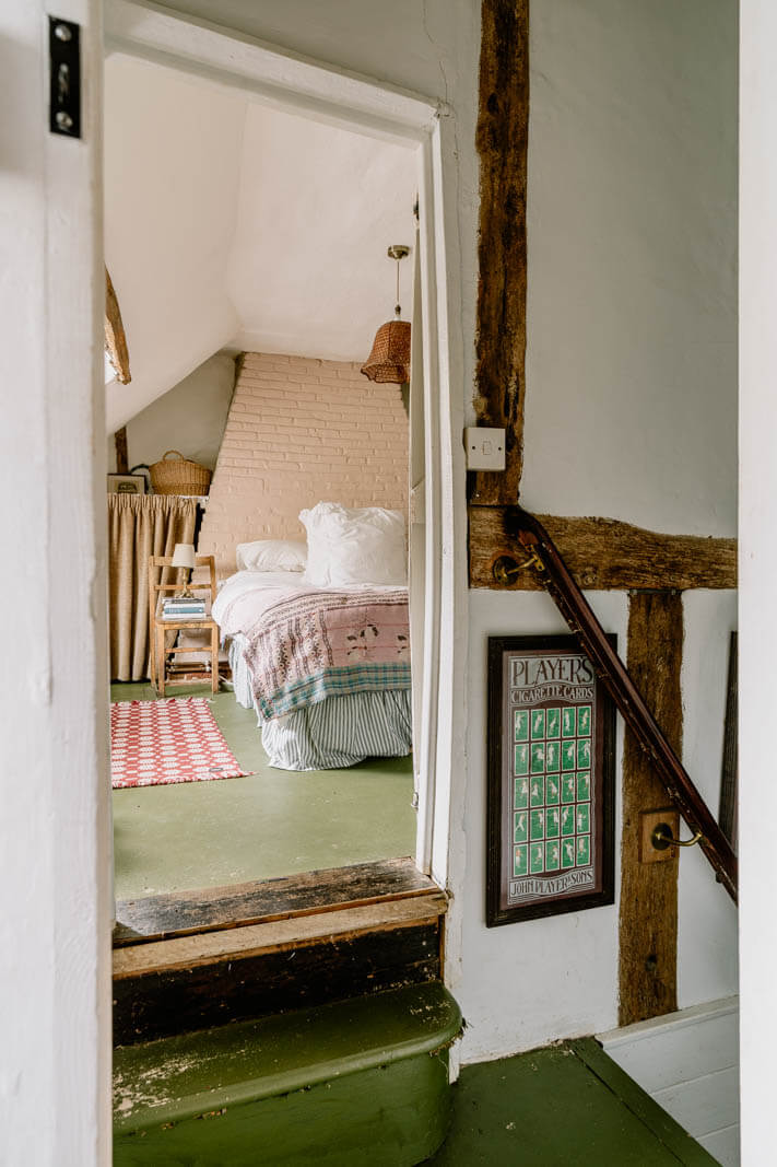 view-into-cottage-bedroom-slanted-ceiling-green-floor-nordroom