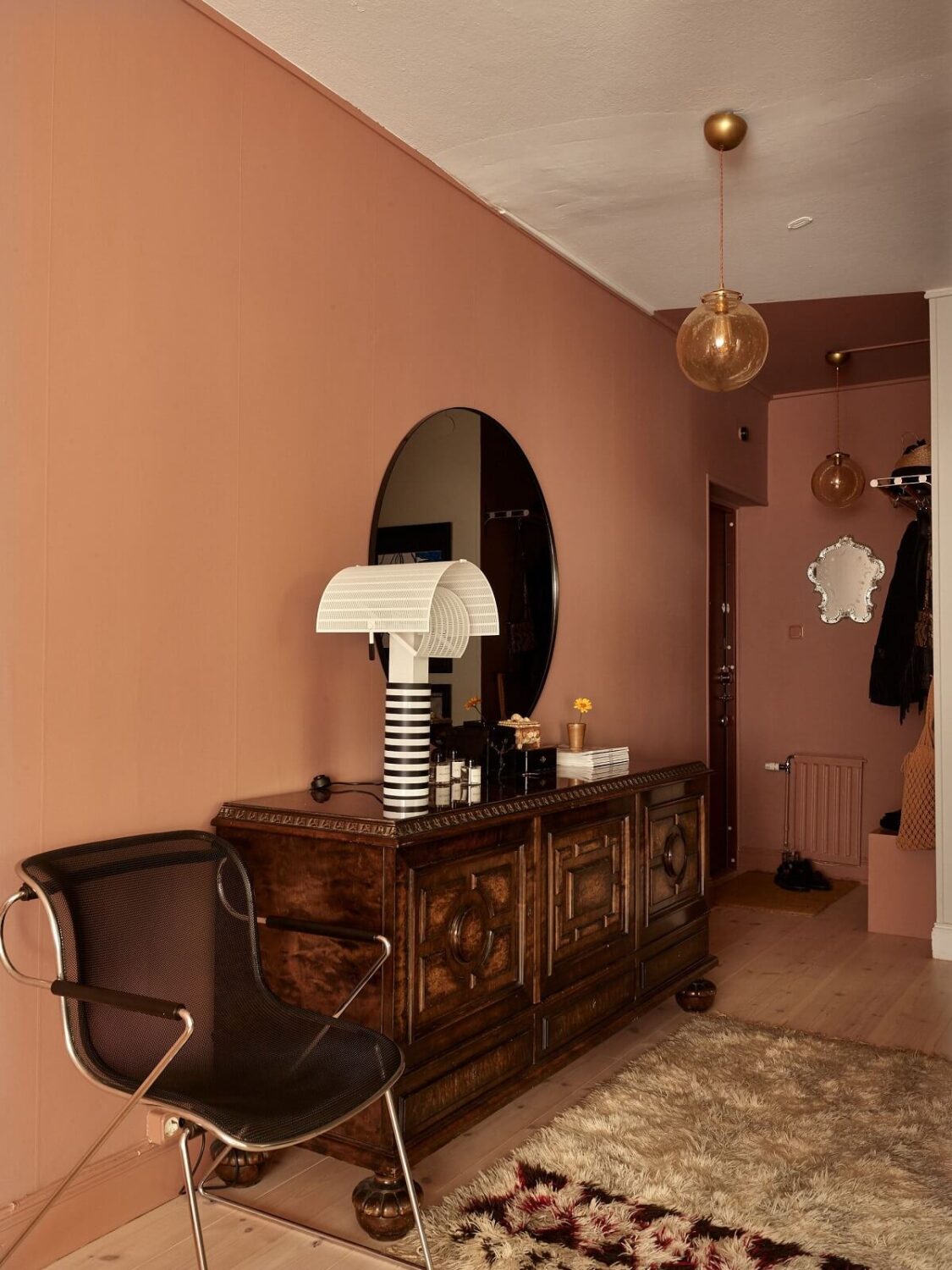 hallway-pink-wall-antique-cabinet-round-mirror-nordroom