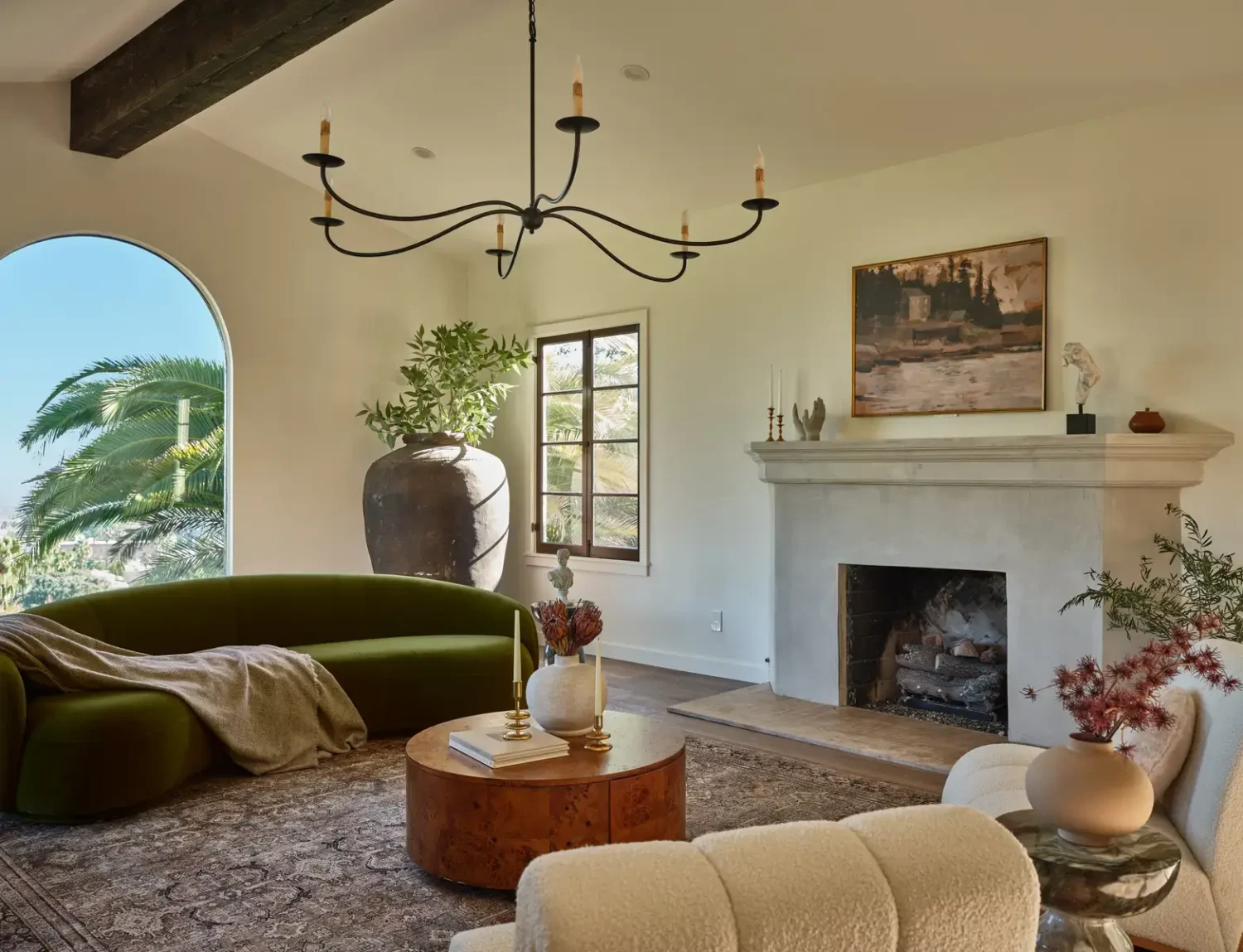 living-room-green-curved-sofa-fireplace-wooden-beams-arched-window-nordroom