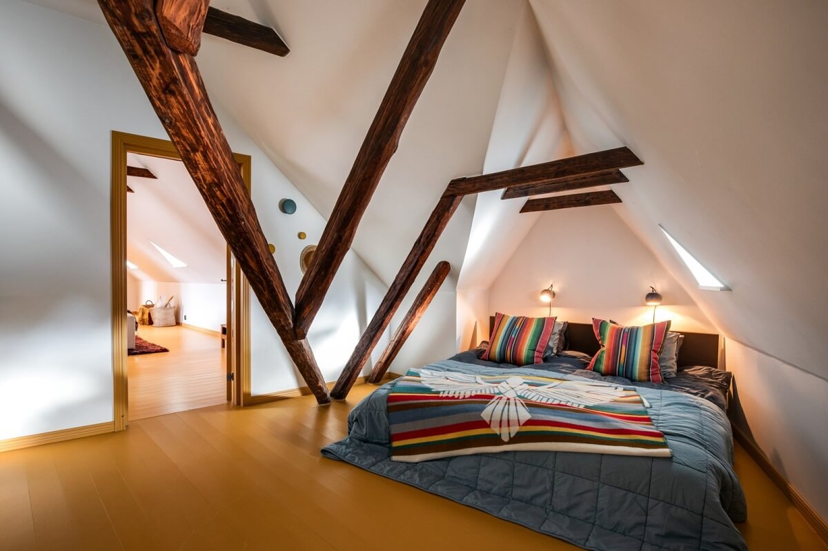 bedroom-pitched-ceiling-wooden-beams-yellow-floor-nordroom