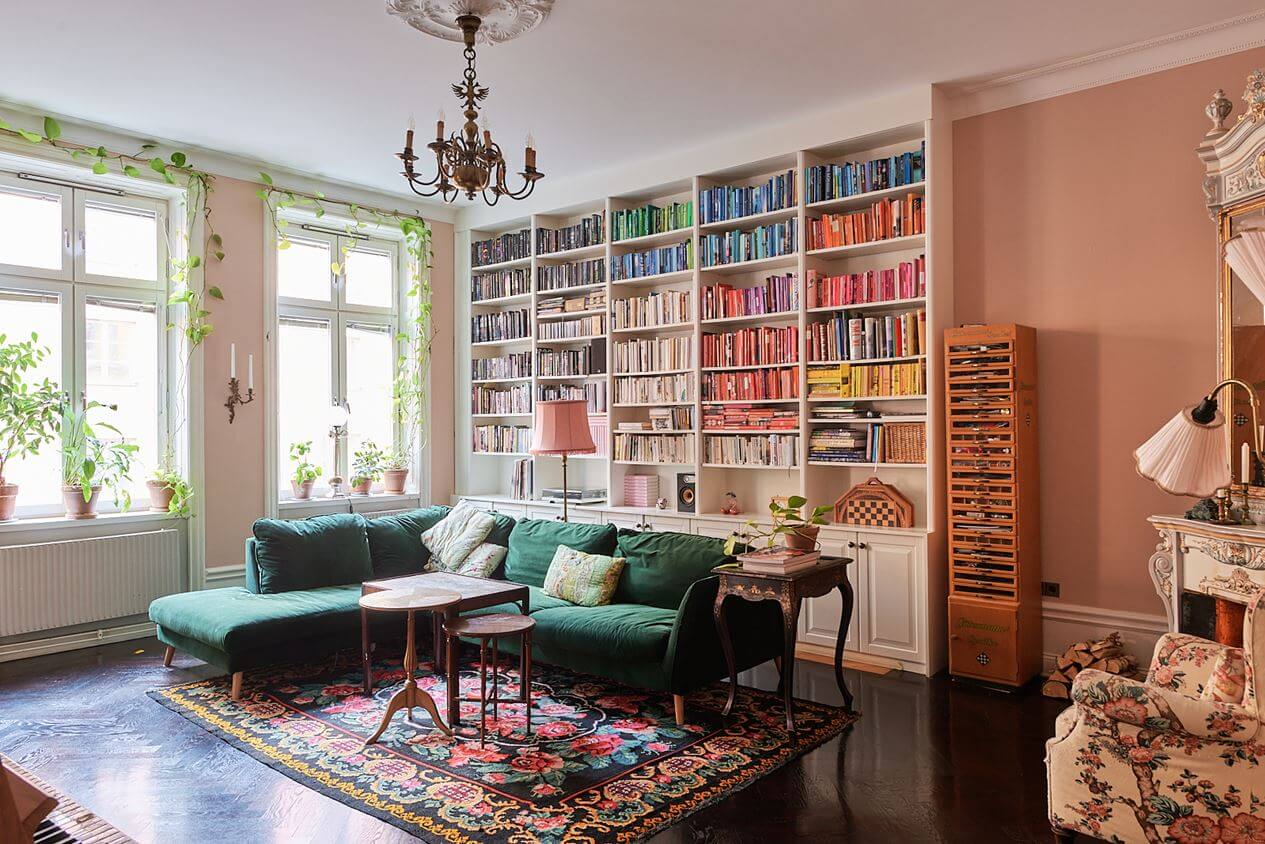 pink-living-room-floral-rug-green-sofa-bookshelves-nordroom